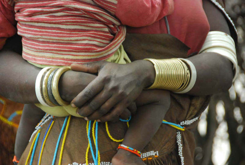 תושבת טנזניה מקומית מחזיקה תינוק